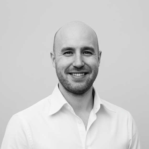 Portrait of Jesper Hartvig wearing a white shirt against a plain background.